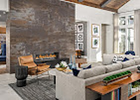 Fireplace lounge with a stone wall, sofa and lounge chairs, Alexan Lake Olympia