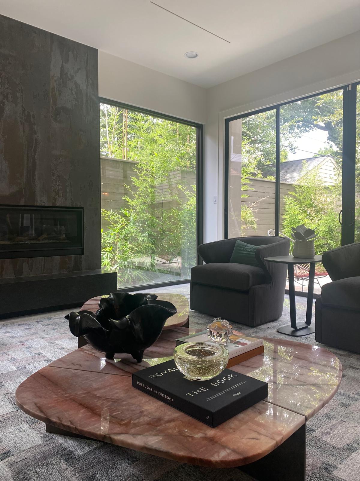 Garden lounge with pink marble coffee tables, charcoal swivel chairs and bamboo garden views, Montrose