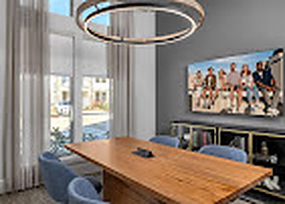 Conference room with a wood table and brass ring chandelier, Alexan Lake Olympia