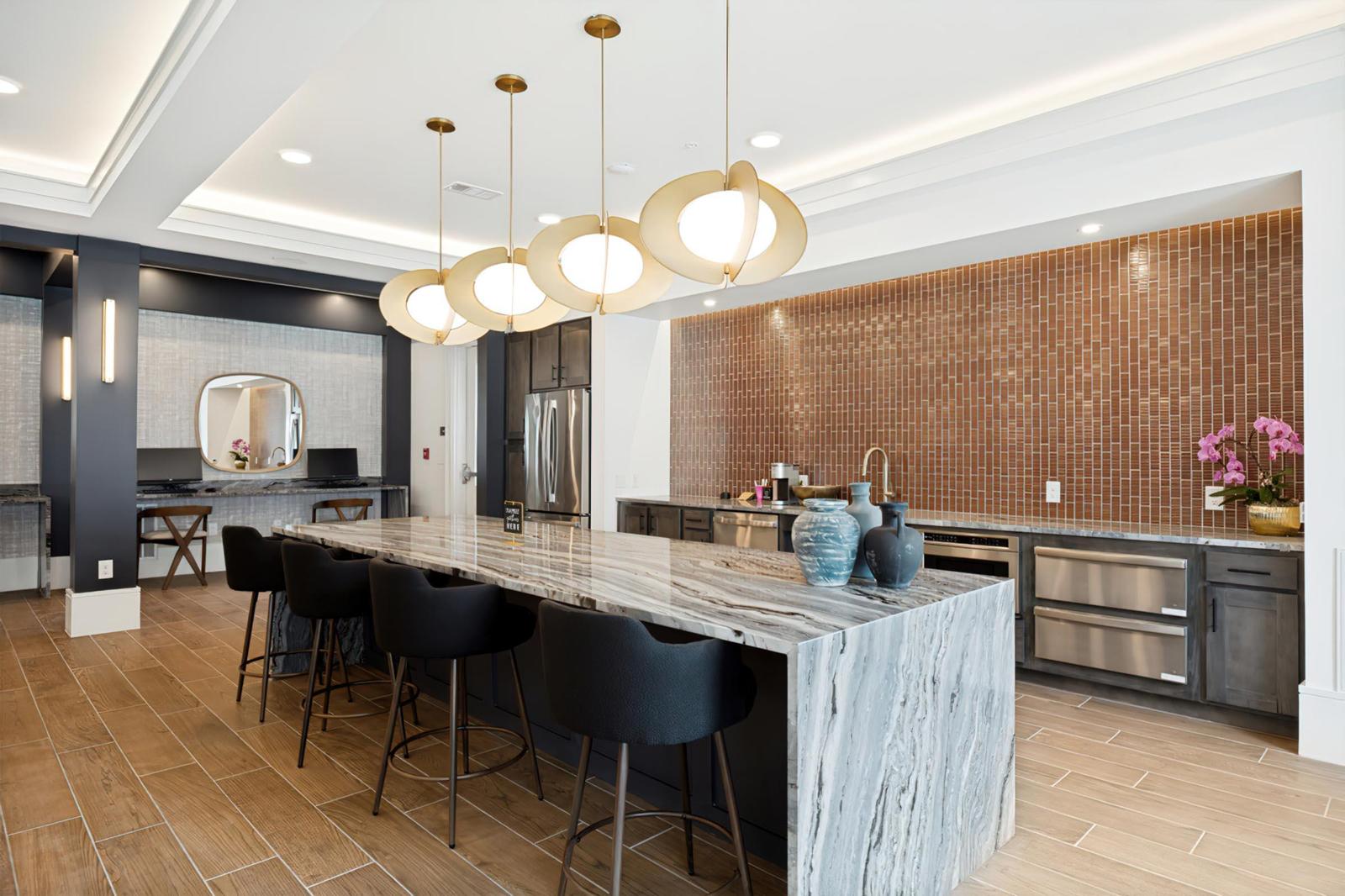 Resident kitchen with a marble waterfall island and gold pendant lights, Allegra at Shreveport