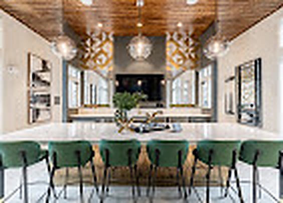 Clubhouse bar with green stools, brass screens and a white island, Alexan Lake Olympia